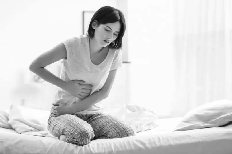 Woman holding her stomach in sudden pain