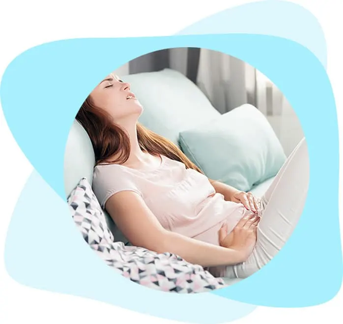 Woman lying on a couch holding her abdomen